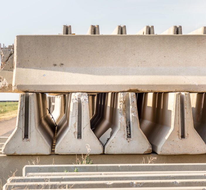 Concrete parts piled up besides a rural road besides the highway