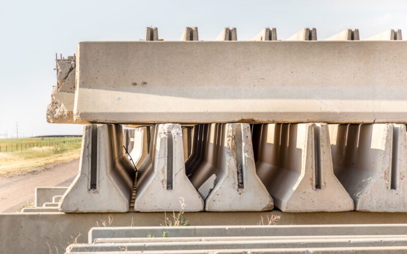 Concrete parts piled up besides a rural road besides the highway