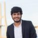 Portrait of good-looking smiling Arabic man in suit. Attractive young businessman with beard and moustache looking at camera. Portrait, international, beauty concept