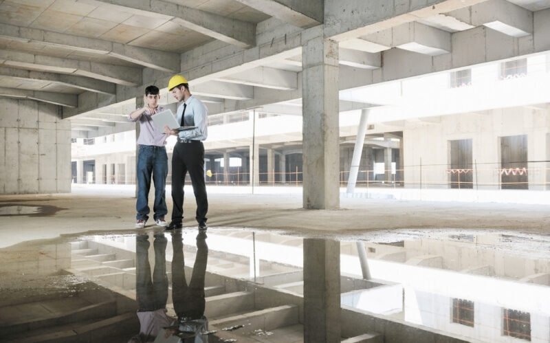 Team of business people in group, architect and engeneer  on construciton site check documents and business workflow on new building